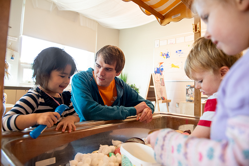 Students work with young children at the Mitchell Center