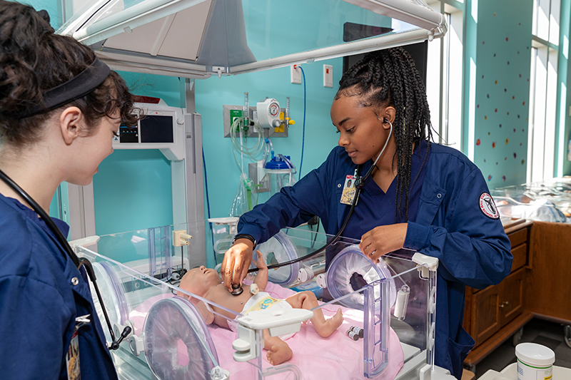 Two nursing students work in the Obstetrics Simulation Lab