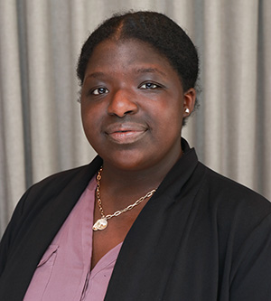 Chelsei Arnold poses for a professional portrait wearing a black blazer against a neutral backdrop.