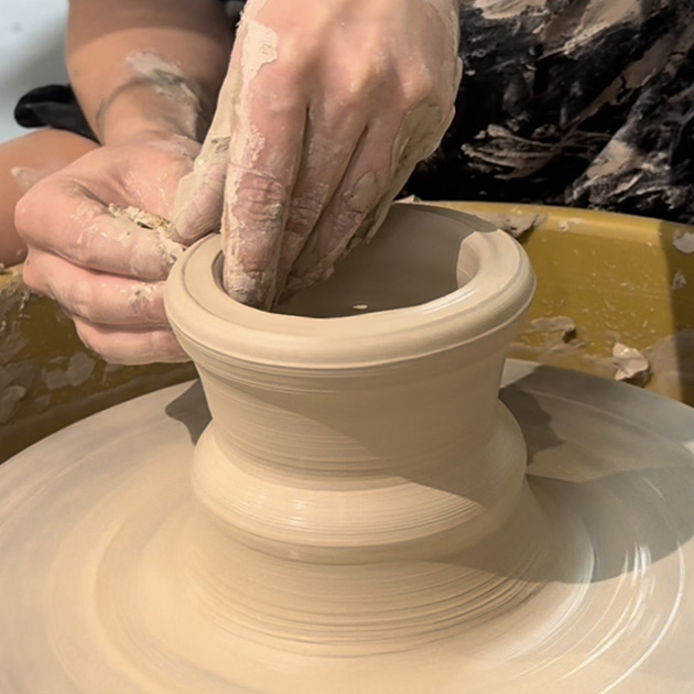 a person throwing clay on a wheel