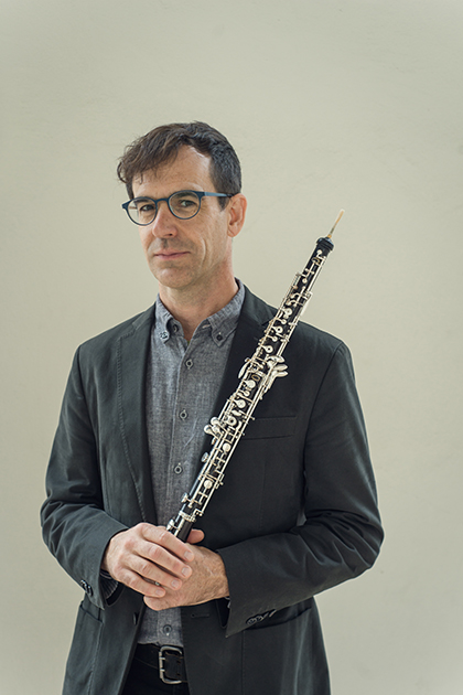 Musician Kyle Bruckmann holding an oboe.