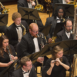 Wind band musicians on stage performing