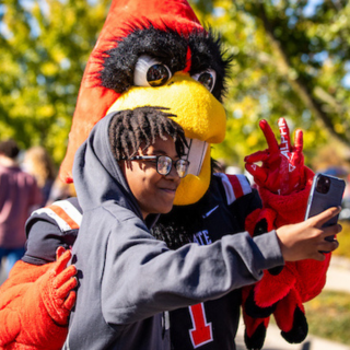 someone taking a photo outside with Charlie Cardinal at Ball State University's CharlieTown
