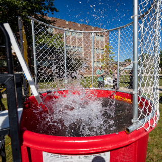 person splashing into red dunk tank on campus
