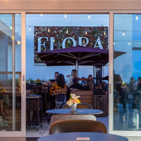 Flora Sign with strand lights lit up and fire pit going