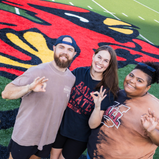 Three students at Scheumann Stadium during the Senior Celebration for Ball State University