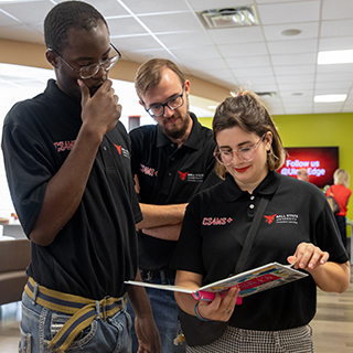 3 students looking at book