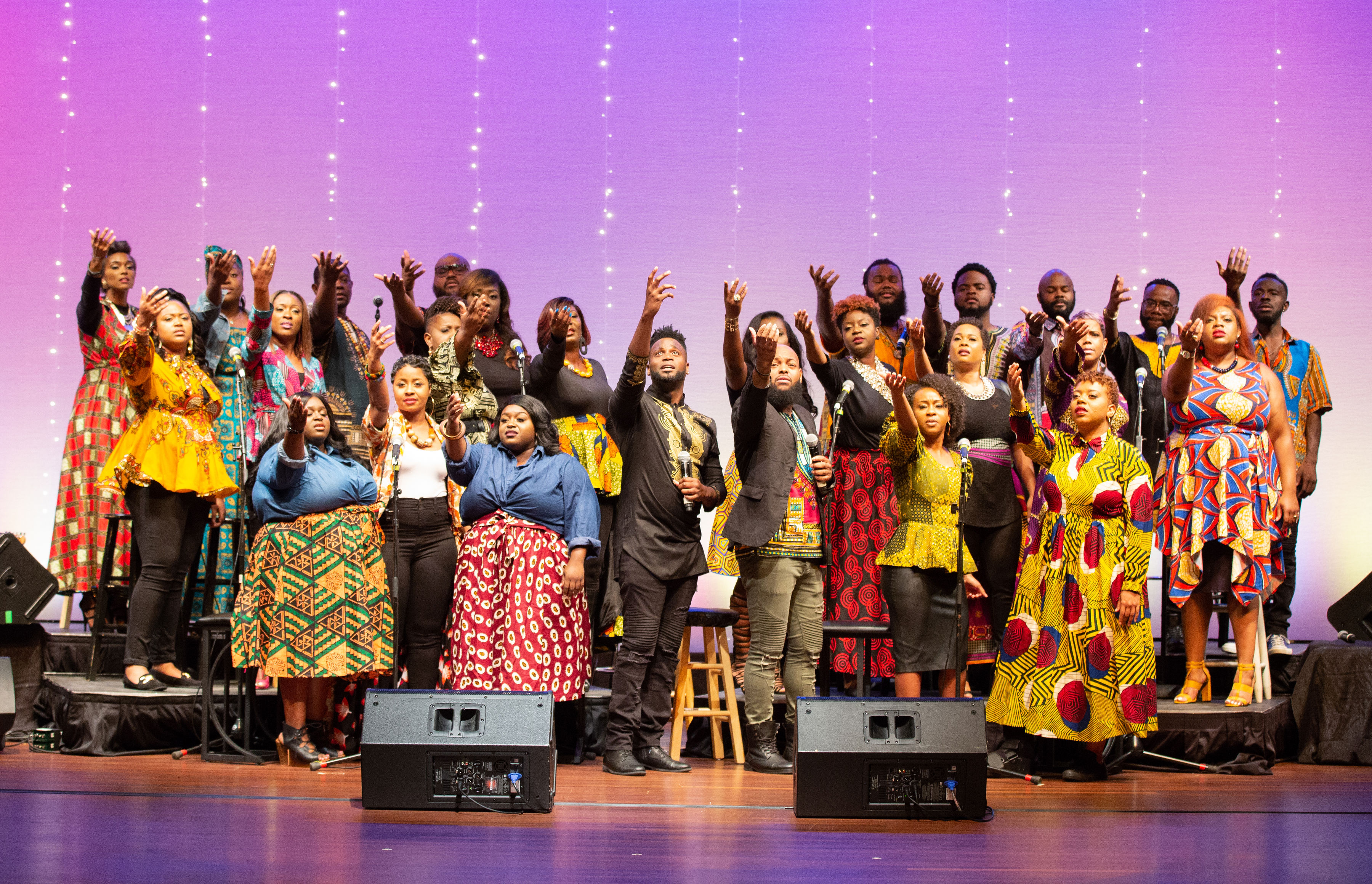 Trey McLaughlin and the Sounds of Zamar perform onstage wearing colorful clothing in various African prints