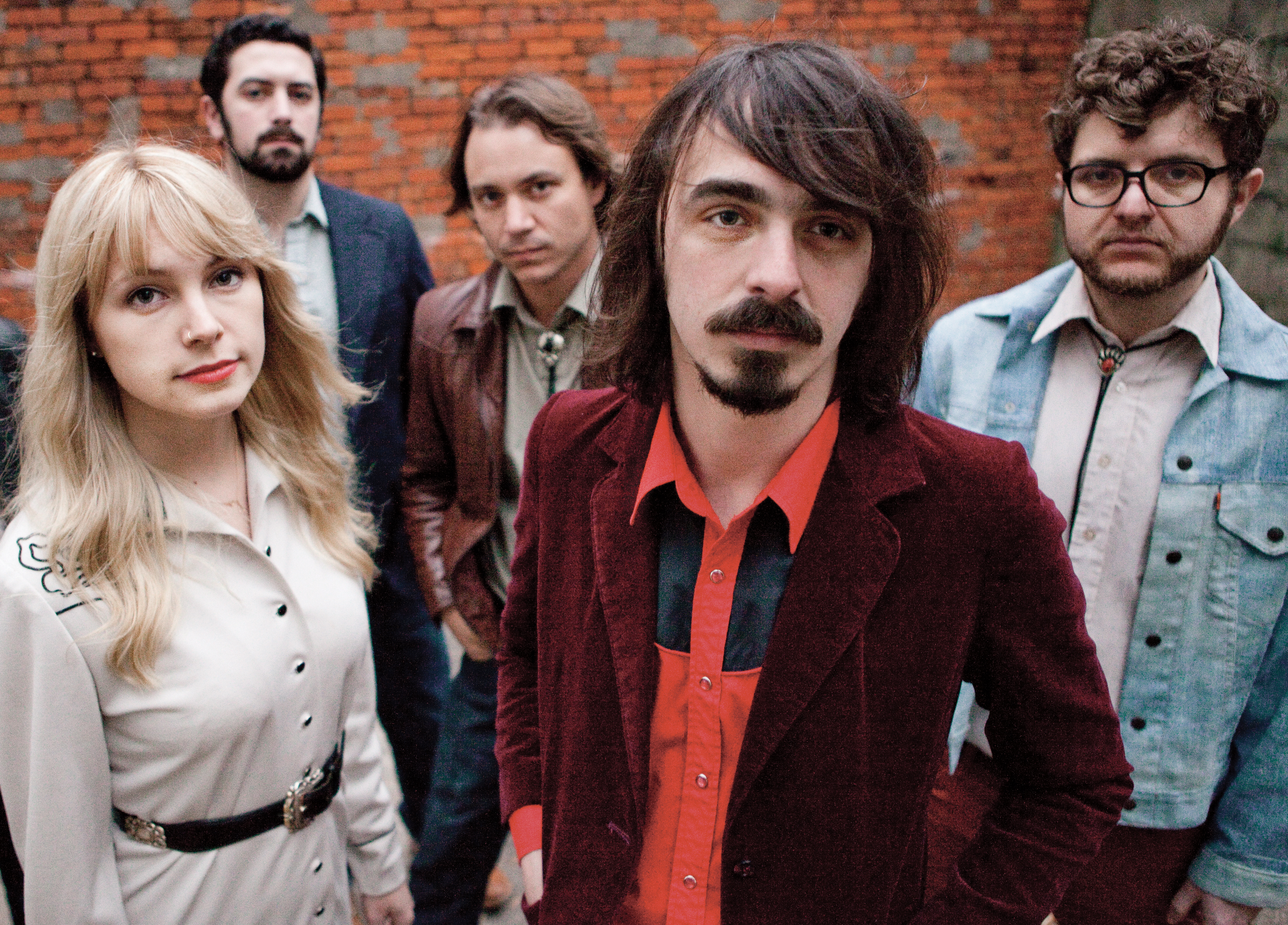 Feufollet pose together in front of a brick wall