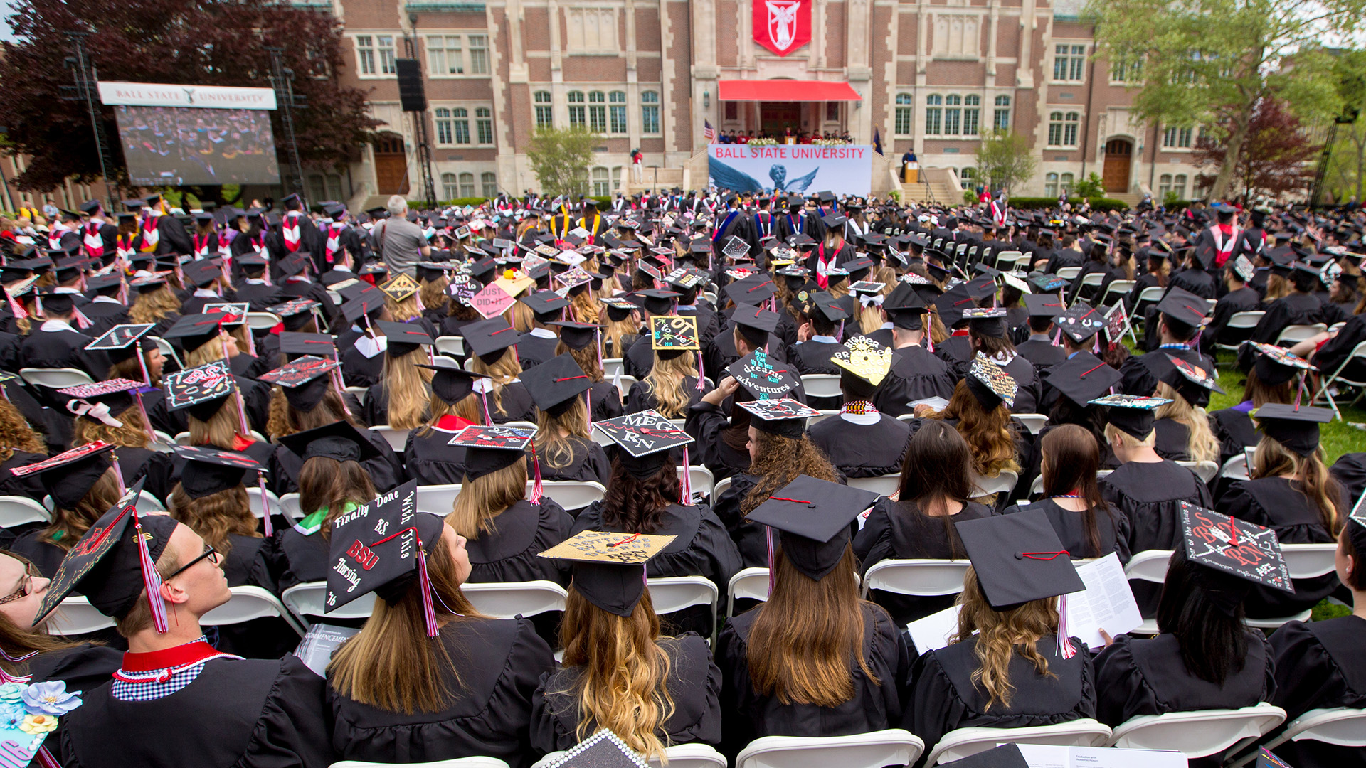 View of graduates from the back facing the stage on the Quad