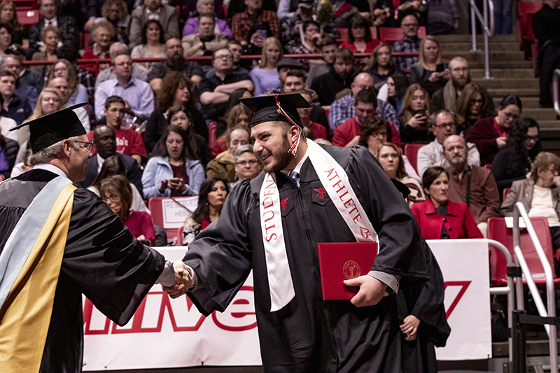 graduate shaking hands with professor at Fall Commencement 2019