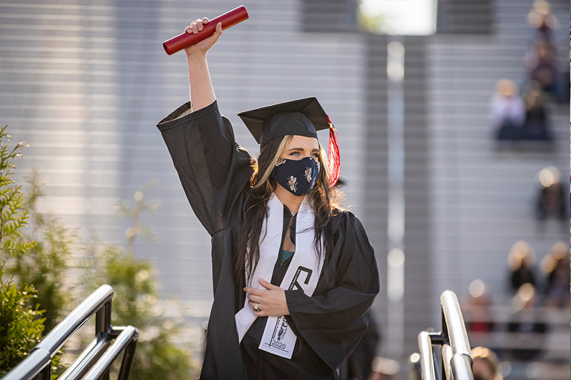 student holding diploma in air