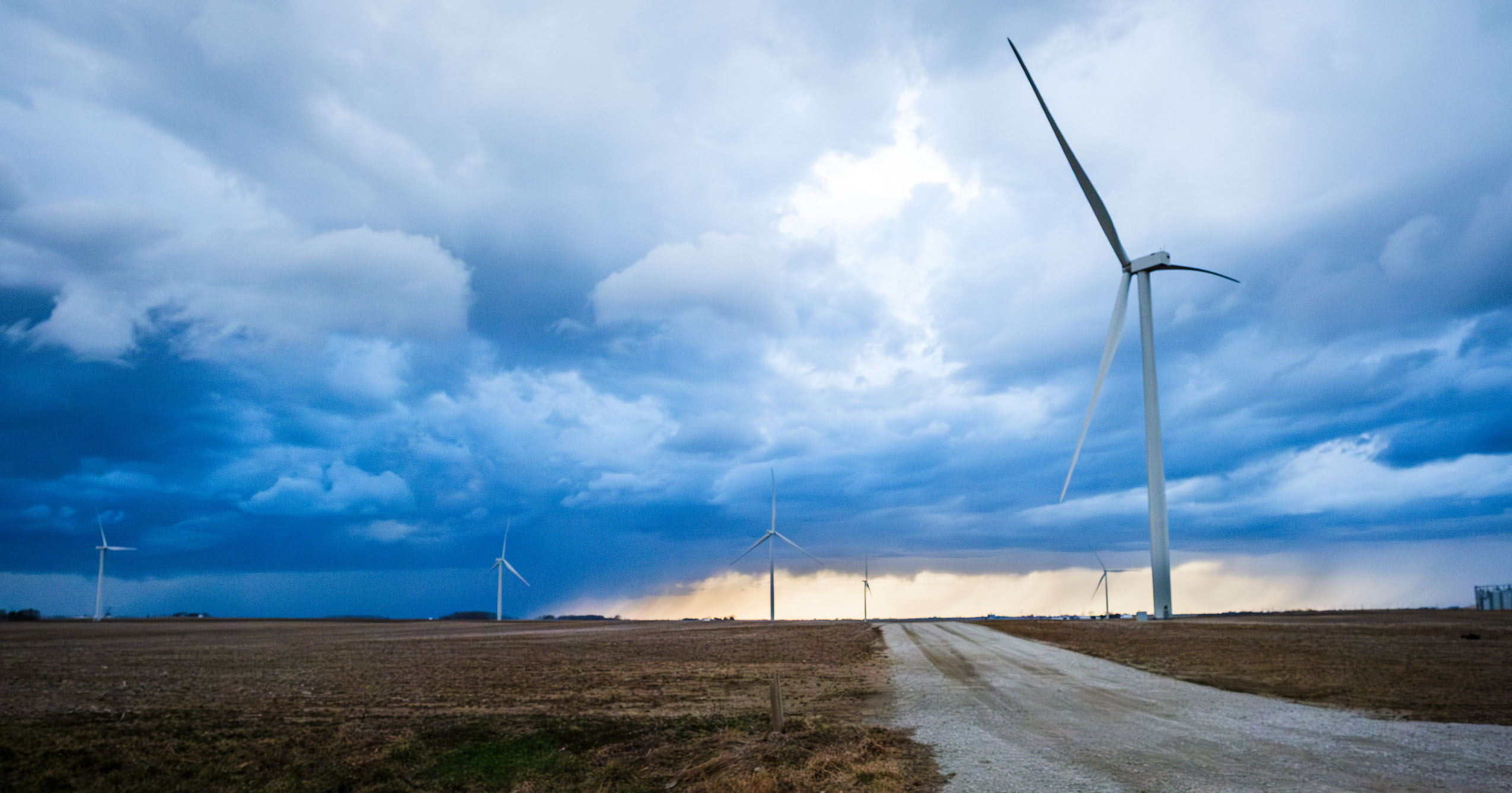 Wind turbines at an Indiana wind farm under a dark, stormy sky.