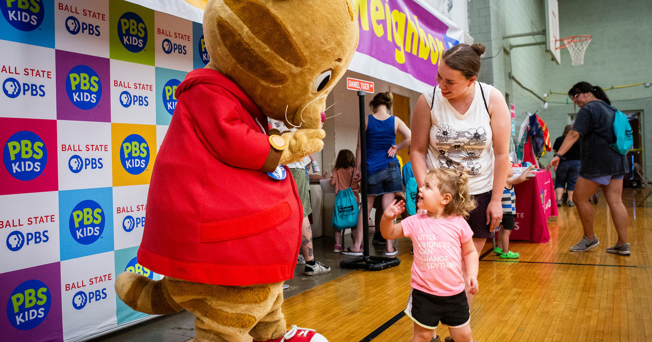 Daniel Tiger greets a young child at a Ball State PBS Be My Neighbor Day event.
