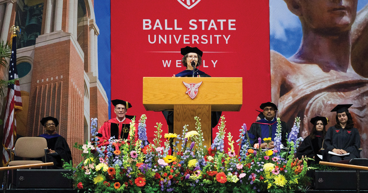 Katherine Denker speaks at the commencement podium in Worthen Arena.