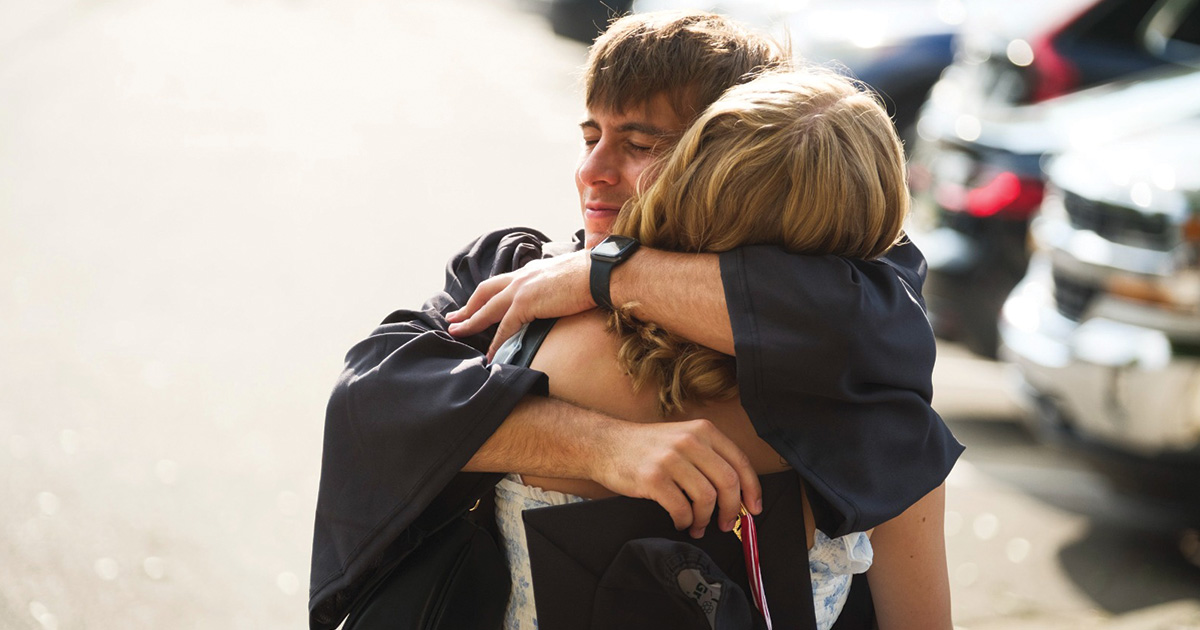 Graduate embraces a family member following the commencement ceremony.